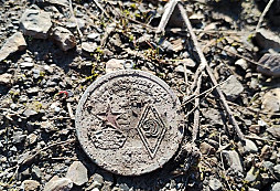 Medaile ležící na zemi